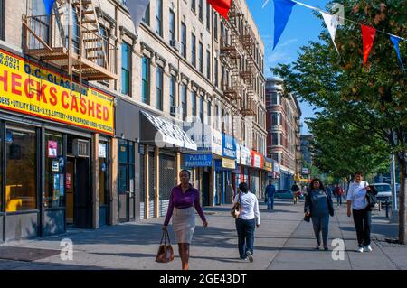 Geschäfte und Gebäude in der Harlem Street am Malcolm X Boulevard und der Lenox Avenue in Harlem in Manhattan in NYC, USA Stockfoto