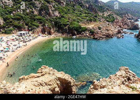 Menschen und Sonnenschirme am Strand von Li Cossi an der Costa Paradiso von Sardinien, Italien Stockfoto