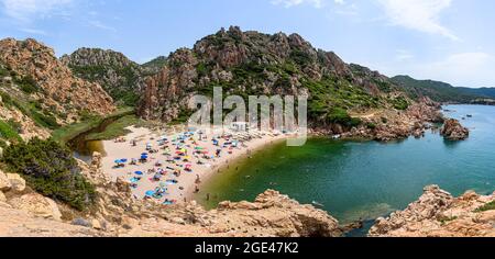 Menschen und Sonnenschirme am Strand von Li Cossi an der Costa Paradiso von Sardinien, Italien Stockfoto