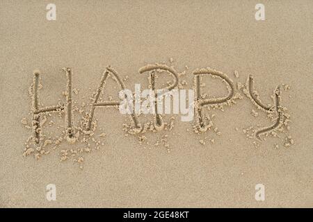 Happy Concept - Inschrift im Sand. Sandige Küste des Meeres. Motivation. Das Wort Happy Time steht am Strand. Urlaub am Ufer Stockfoto