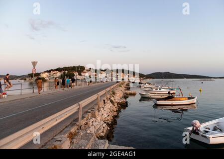 Rogoznica, Kroatien-8. Juli 2021: Schöner, goldener Sonnenuntergang über der touristischen Stadt Rogoznica an der dalmatinischen Küste Kroatiens, oberhalb des Stadthafens mit anc Stockfoto