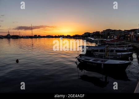 Rogoznica, Kroatien-8. Juli 2021: Schöner, goldener Sonnenuntergang über der touristischen Stadt Rogoznica an der dalmatinischen Küste Kroatiens, oberhalb des Stadthafens mit anc Stockfoto