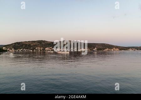 Rogoznica, Kroatien-8. Juli 2021: Schöner goldener Sonnenuntergang über der touristischen Stadt Rogoznica an der dalmatinischen Küste Kroatiens, mit Segelbooten vor Anker i Stockfoto