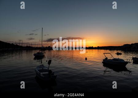 Rogoznica, Kroatien-8. Juli 2021: Schöner, goldener Sonnenuntergang über der touristischen Stadt Rogoznica an der dalmatinischen Küste Kroatiens, oberhalb des Stadthafens mit anc Stockfoto