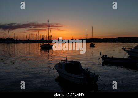 Rogoznica, Kroatien-8. Juli 2021: Schöner, goldener Sonnenuntergang über der touristischen Stadt Rogoznica an der dalmatinischen Küste Kroatiens, oberhalb des Stadthafens mit anc Stockfoto