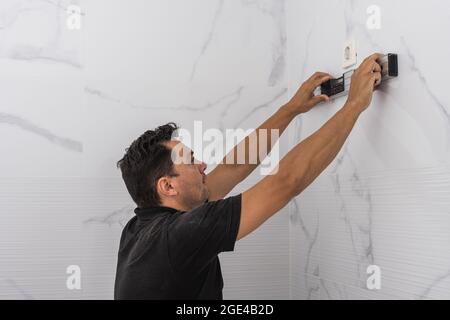 Mann mit einer Wasserwaage an einer Küchenwand Stockfoto