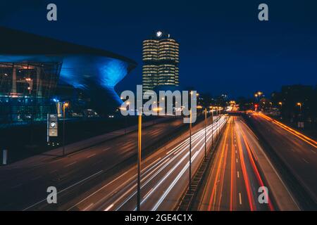 Lighttrails einer befahrenen Straße vor dem BMW-Hauptquartier Stockfoto