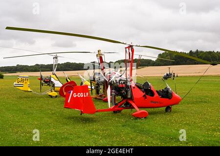 Popham, bei Basingstoke, England - August 2021: Reihe von zweisitzigen Gyrocoptern auf einem Grasflugplatz Stockfoto