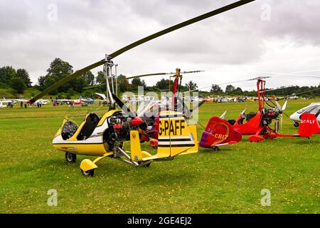 Popham, bei Basingstoke, England - August 2021: Reihe von zweisitzigen Gyrocoptern auf einem Grasflugplatz Stockfoto