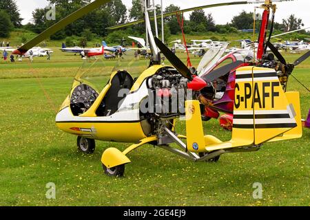 Popham, bei Basingstoke, England - August 2021: Zweisitzige Gyrocopter, die auf einem Grasflugplatz geparkt ist Stockfoto