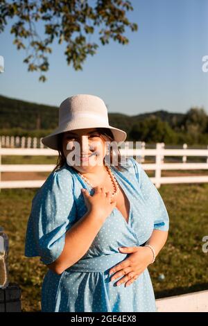 Ehrliche Frau im Hut auf dem Ackerland genießen Sie den Sommer Stockfoto