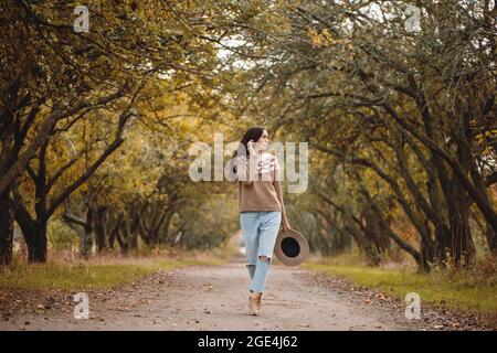 Schöne junge Frau, die im Herbstpark spazieren geht. Stockfoto