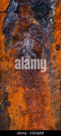 Rostige Metalloberfläche mit Grunge-Textur und stark verwitterten Strukturen in Orange und Blau Stockfoto