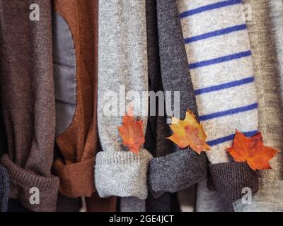 Herbst- und Winterkleidung hängt an Kleiderbügeln in der Garderobe. Keine Leute, Nahaufnahme. Konzept von Schönheit und Mode Stockfoto