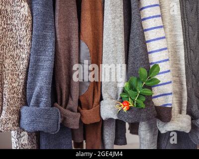 Herbst- und Winterkleidung hängt an Kleiderbügeln in der Garderobe. Keine Leute, Nahaufnahme. Konzept von Schönheit und Mode Stockfoto
