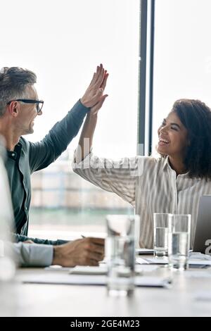 Zwei glückliche internationale Geschäftspartner geben highfive im modernen Büro. Stockfoto