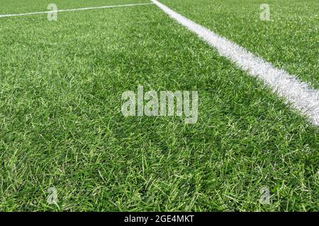Fußballhintergrund. Grüne Kunstrasen Fußball-Sportplatz mit weißen Streifen Linie Stockfoto