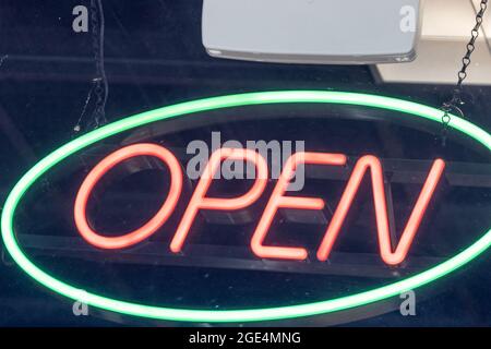 Neonrot und blau offenes Schild im Fenster Stockfoto