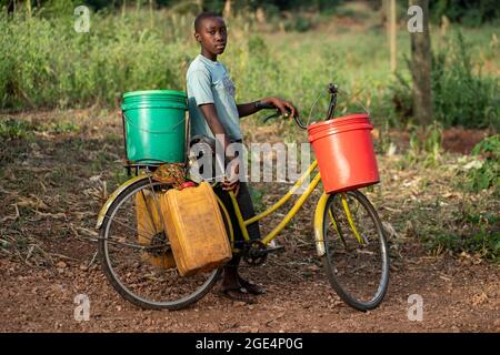 Mvomero, Washington, Tansania. August 2021. Die Studentin des EMFERD-Waisenhauses (Eric Memorial Foundation for the Education and Rehabilitation of the Disabled) in Mvomero, Tansania, fährt mit ihrem Fahrrad, um Wasser zu holen.zwei Wasserquellen, ein Fluss und ein Brunnen, befinden sich beide mehr als einen Kilometer vom Schlafsaal der Mädchen entfernt. Jeder Bewohner trägt bis zu 20 Liter Wasser pro Tag, um den Bedarf des Waisenhauses zu decken. Kredit: ZUMA Press, Inc./Alamy Live Nachrichten Stockfoto