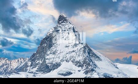 Ikonischer Blick auf den Gipfel des Snowy Matterhorn mit dramatischen Wolken, Schweizer Alpen, Wallis, Schweiz. Stockfoto