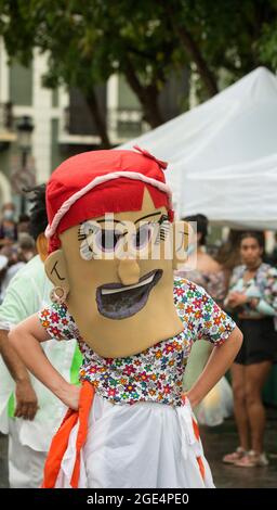 Cabezudos (Big Head) tanzen auf der De Armas Plaza nach einem Sommerregen in Old San Juan, Puerto Rico, USA. Stockfoto