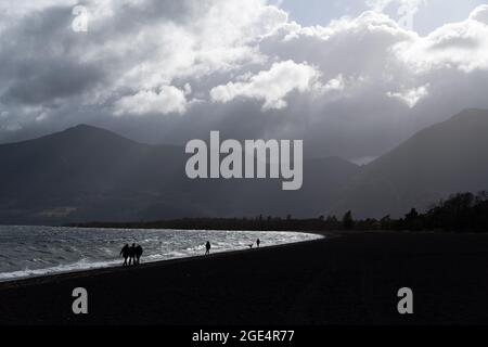 Pucon, Araukanien, Chile. August 2021. Am Montagmorgen, vor dem Sturm, wandern die Menschen am Ufer des Lago Villarrica in Pucon im Süden Chiles entlang. Für diese Woche wird von der Hauptstadt Santiago im Süden schlechtes Wetter erwartet, bei dem es der wichtigste Regen des Jahres für die südzentrale Zone Chiles sein könnte. (Bild: © Matias Basualdo/ZUMA Press Wire) Bild: ZUMA Press, Inc./Alamy Live News Stockfoto