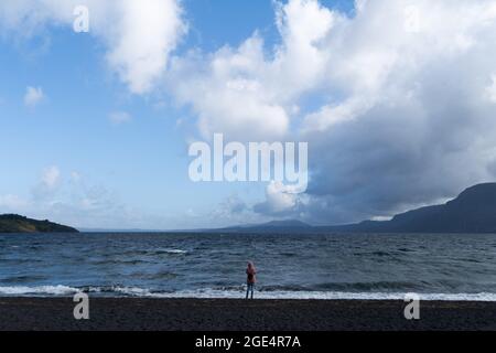 Pucon, Araukanien, Chile. August 2021. Eine Frau zeichnet mit ihrem Handy die Wellen auf, die sich am Montagmorgen vor dem Sturm im See von den starken Winden am Villarrica-See in Pucon im Süden Chiles gebildet haben. Für diese Woche wird von der Hauptstadt Santiago im Süden schlechtes Wetter erwartet, bei dem es der wichtigste Regen des Jahres für die südzentrale Zone Chiles sein könnte. (Bild: © Matias Basualdo/ZUMA Press Wire) Bild: ZUMA Press, Inc./Alamy Live News Stockfoto