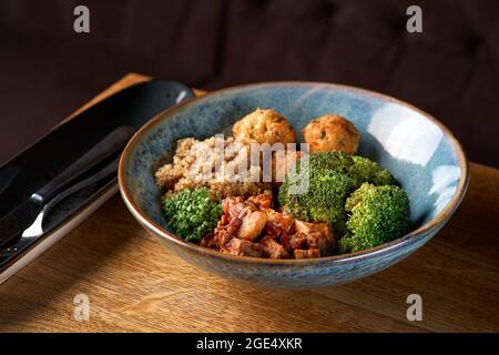 Buddha-Schüssel mit Quinoa, Brokkoli und Tofu-Sauce mit Pilzen. Stockfoto