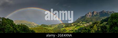 Regenbogen in einem kleinen Bergdorf Stockfoto
