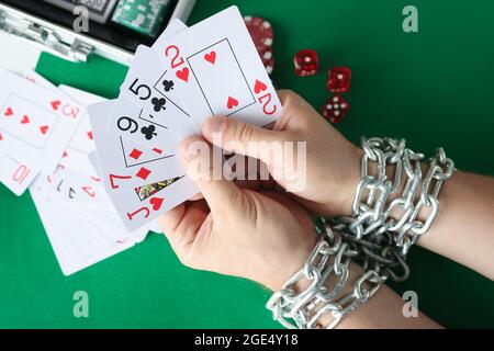 Männer Hände sind mit Kette gebunden und halten Spielkarten aus der Nähe Stockfoto