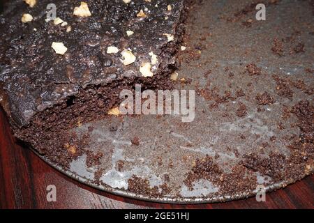 Hausgemachte Schokoladenkuchen auf Backform, Schokoladenkuchen mit Nüssen, auf Holzhintergrund. Stockfoto