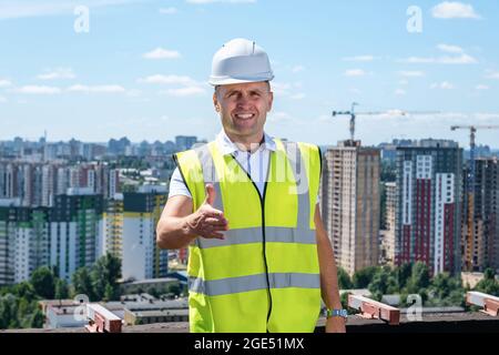Der Baumeister hält eine Hand für einen Handschlag Stockfoto
