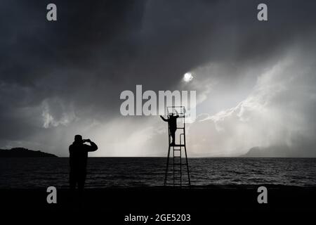 Pucon, Araukanien, Chile. August 2021. Touristen fotografieren sich am Strand von Pucon, am ersten Tag eines Sturms, der von der Hauptstadt Santiago in den Süden Chiles angekündigt wurde. Es wird erwartet, dass es sich um den Hauptregen des Jahres in der südlichen Zentralzone Chiles handelt. (Bild: © Matias Basualdo/ZUMA Press Wire) Bild: ZUMA Press, Inc./Alamy Live News Stockfoto