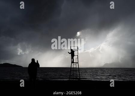 Pucon, Araukanien, Chile. August 2021. Touristen fotografieren sich am Strand von Pucon, am ersten Tag eines Sturms, der von der Hauptstadt Santiago in den Süden Chiles angekündigt wurde. Es wird erwartet, dass es sich um den Hauptregen des Jahres in der südlichen Zentralzone Chiles handelt. (Bild: © Matias Basualdo/ZUMA Press Wire) Bild: ZUMA Press, Inc./Alamy Live News Stockfoto