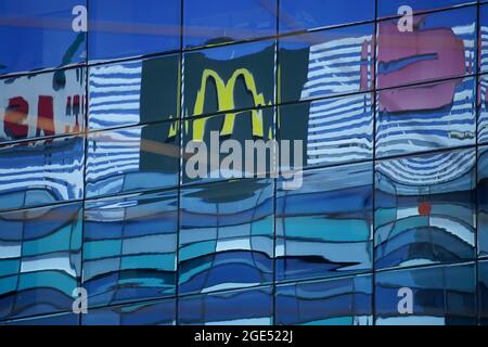 Bukarest, Rumänien - 11. August 2021: Die Spiegelung eines McDonald's-Fast-Food-Unternehmens-Logos ist auf den Fenstern eines hohen Gebäudes in Bukarest, Ro, zu sehen Stockfoto