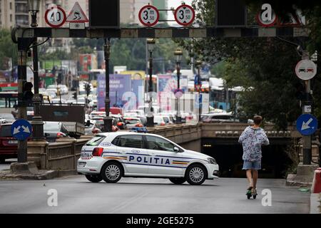 Bukarest, Rumänien - 12. August 2021: Ein Polizist lenkt Autos im Verkehr ab, um einen gesperrten Teil der Straße zu umgehen, weil ein Autounfall auf einem Boulevard in B stattgefunden hat Stockfoto
