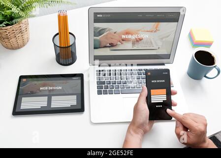 Web Developer entwirft Websites für verschiedene Gerätetypen. Responsive Webdesign Konzept Stockfoto