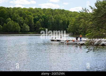 Moskau, Russland - 23. Mai 2021: Tsaritsinsky Pond, Katamaran-Verleih, Urlauber segeln vom Ufer in Schwimmwesten Stockfoto