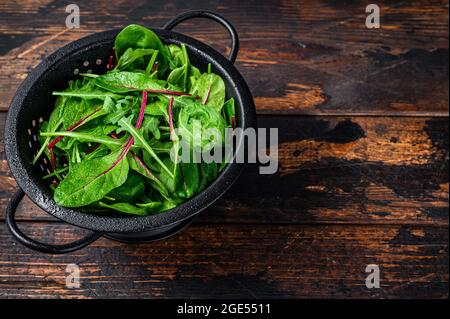 Frisches, rohes, gemischtes Gemüse, Spinat, mangold und Rucola. Dunkler Holzhintergrund. Draufsicht. Speicherplatz kopieren Stockfoto