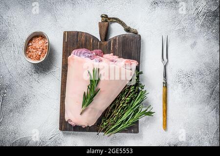 Rohes Schweinshaxe eisbein zum Kochen mit Kräutern. Weißer Hintergrund. Draufsicht Stockfoto