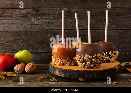 Herbstliche Zuckeräpfel mit Schokolade und Karamell, Seitenansicht auf einer rustikalen Holzplatte Stockfoto
