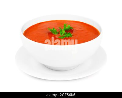 Hausgemachte Tomatensuppe in einer weißen Schüssel mit Untertasse. Seitenansicht isoliert auf weißem Hintergrund. Stockfoto
