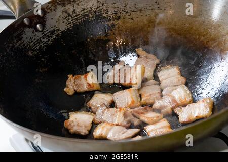 In Scheiben geschnittener Schweinebauch in einem heißen Wok gebraten Stockfoto