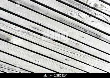 Holzwand aus diagonalen Brettern mit hellen Streifen. Hintergrund Stockfoto