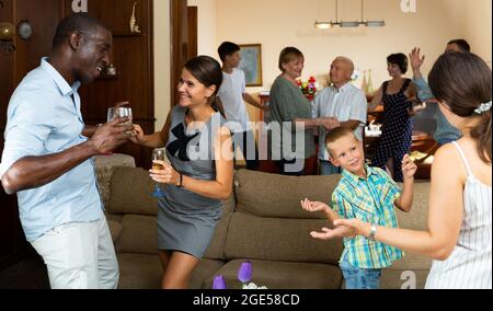 Großes glückliches multiethnisches Familientreffen im Elternhaus während der Familienfeier Stockfoto