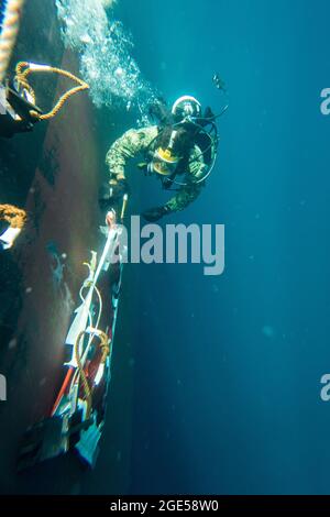 Brandon Barreto, der Marine Diver der 2. Klasse, der der Mobile Diving Salvage Unit (MDSU) 2 zugewiesen wurde, führt während eines großen Trainings (LSE 2021) Unterwasser-Kampfschadenreparaturen (BDR) auf dem Zerstörer USS Gonzales (DDG-66) der Arleigh Burke-Klasse durch. LSE 2021 demonstriert die Fähigkeit der Marine, weltweit präzise, tödliche und überwältigende Gewalt über drei Seestreitkommandos, fünf nummerierte Flotten und 17 Zeitzonen hinweg einzusetzen. LSE 2021 vereint Live- und synthetische Trainingsfunktionen, um eine intensive, robuste Trainingsumgebung zu schaffen. Es wird High-Fidelity-Schulungen und den realen Betrieb mit bui verbinden Stockfoto