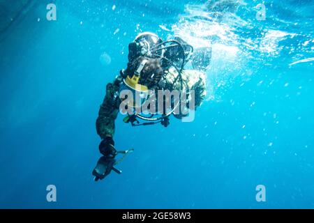 Brandon Barreto, der Marine Diver der 2. Klasse, der der Mobile Diving Salvage Unit (MDSU) 2 zugewiesen wurde, führt während eines großen Trainings (LSE 2021) Unterwasser-Kampfschadenreparaturen (BDR) auf dem Zerstörer USS Gonzales (DDG-66) der Arleigh Burke-Klasse durch. LSE 2021 demonstriert die Fähigkeit der Marine, weltweit präzise, tödliche und überwältigende Gewalt über drei Seestreitkommandos, fünf nummerierte Flotten und 17 Zeitzonen hinweg einzusetzen. LSE 2021 vereint Live- und synthetische Trainingsfunktionen, um eine intensive, robuste Trainingsumgebung zu schaffen. Es wird High-Fidelity-Schulungen und den realen Betrieb mit bui verbinden Stockfoto