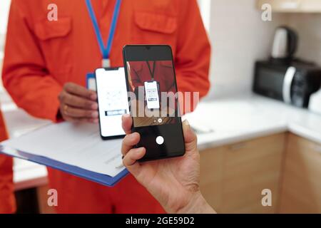 Hände einer Frau, die QR-Code auf dem Smartphone scannt, der auf der Website zur berührungslosen Zahlung weitergeleitet wird Stockfoto
