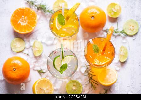 Farbenfrohes Sommergetränk saftige, exotische Sommergetränke erfrischende Vielfalt an kalten Getränken Gläser frisches Obst auf Eis hausgemachter Cocktailtee mit Mojito-Zitrone Stockfoto