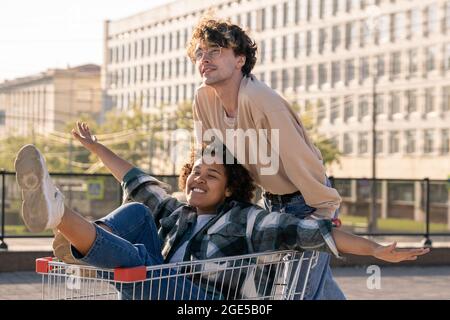 Liebevolles Teenager-Paar, das im Freien gegen moderne Gebäude Freizeit genießt Stockfoto